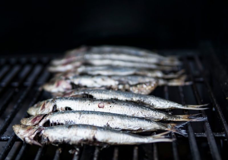Espeto de sardinas asándose a la brasa en la costa de Estepona